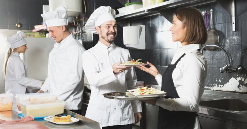 Hospitality design expo 2020 sponsors | friendly woman waiter collecting freshly prepared dishes | hospitality design expo and conference 2020
