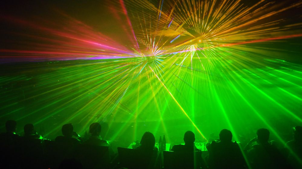 Live design international 2020 las vegas | row of people seated as audience members facing a green and yellow laser light show | live design international 2020 | featured
