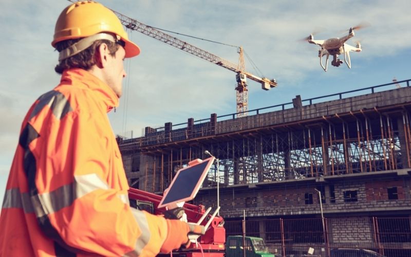 Drone operated by construction worker on building site | commercial uav expo americas 2021