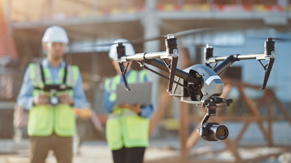 Two specialists use drone on construction site | commercial uav expo americas | featured